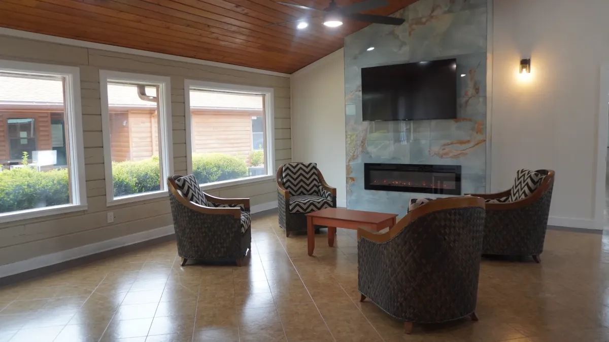 The cozy lounge at The Wave of North Florida, with armchairs gathered around a stone fireplace
