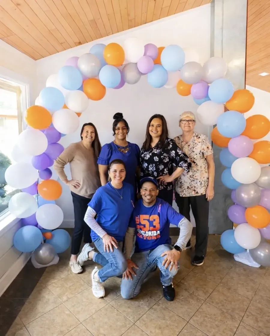 The compassionate care team at The Wave of North Florida gathered under a balloon arch in the facility lobby